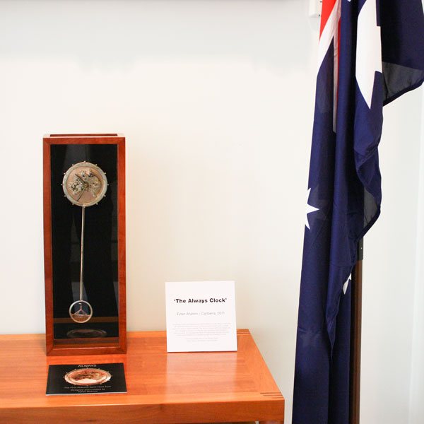 The Always Clock standing on a plinth beside an Australian flag