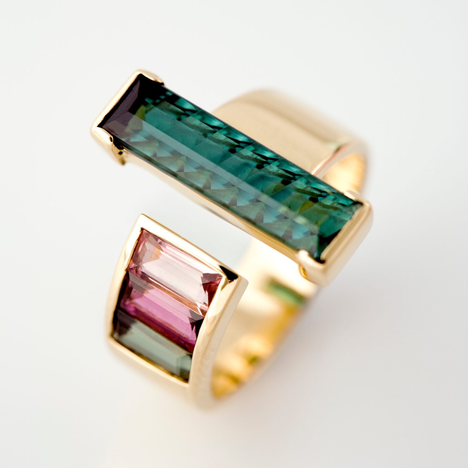 Ring with a long green tourmaline bar above a shorter pink tourmaline bar, in yellow gold