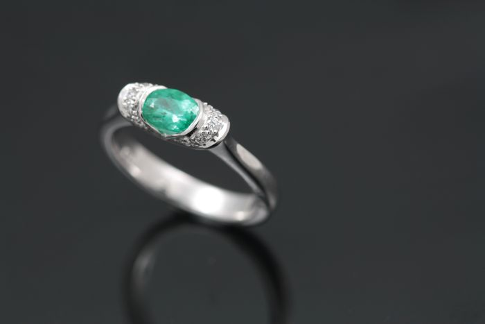 Paraiba Tourmaline and diamond ring: a Paraiba Tourmaline set with diamonds on either side in 18 karat white gold