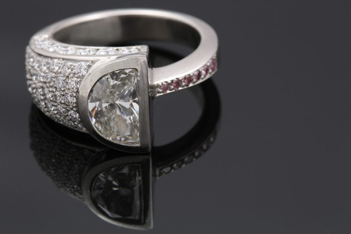 Half-moon diamond ring: a half-moon diamond with pavé set colourless diamonds on one side and pink diamonds on the other in 18 karat white gold