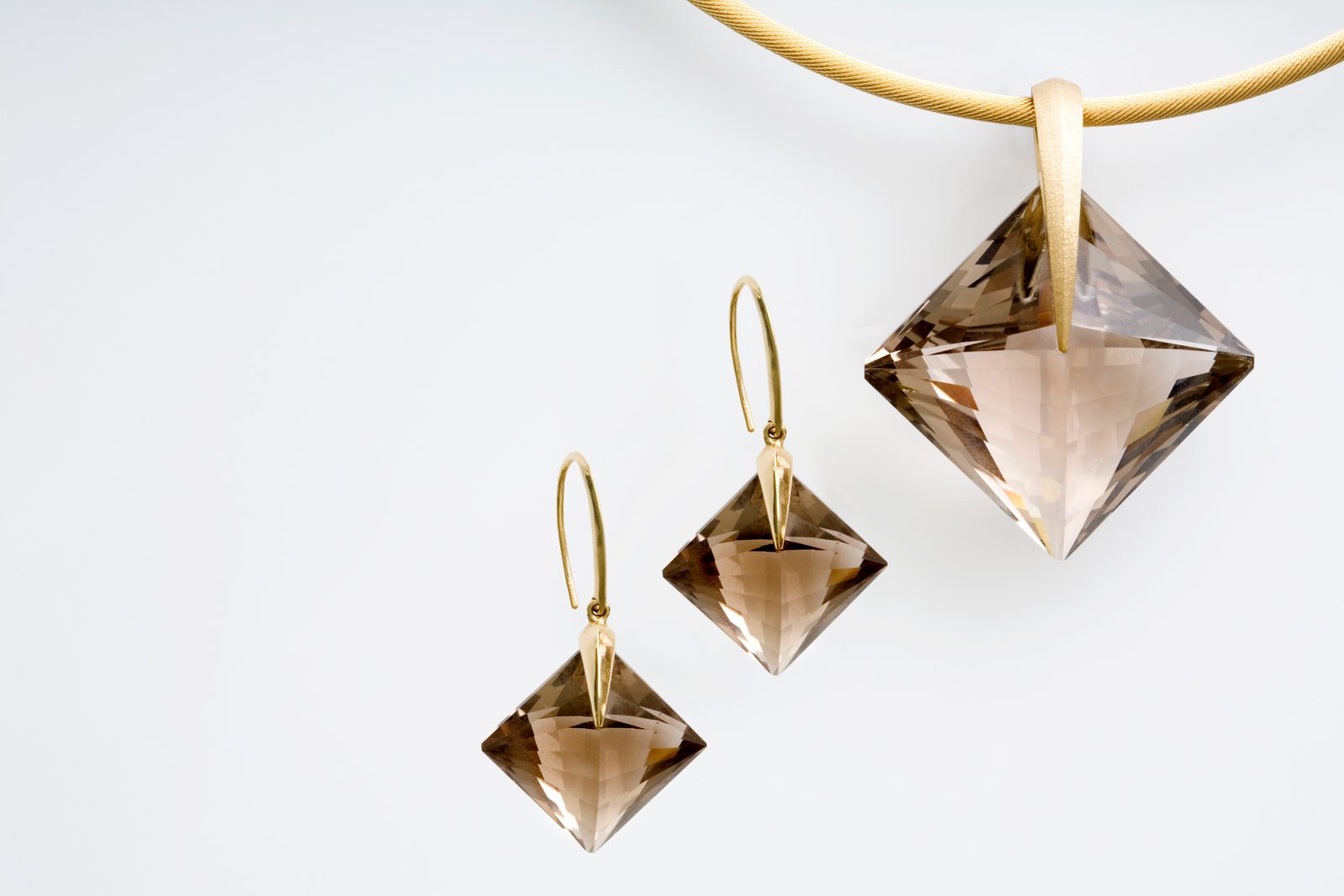 Square smoky quartz drop earrings and a matching pendant on a gold cable