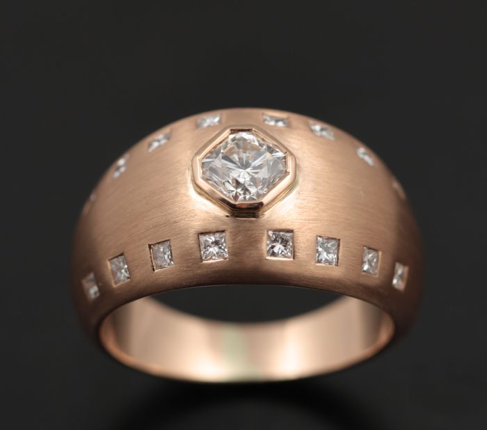 Domed ring: emerald cut diamond with princess cut diamonds in a textured 18 karat rose gold ring