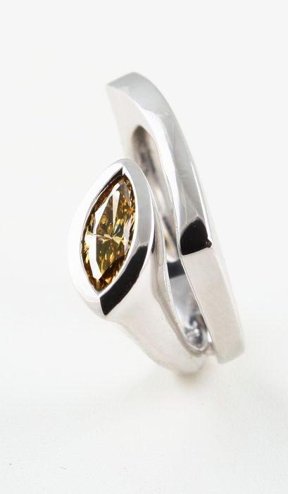 Yellow diamond crossover ring: a yellow diamond set in 18 karat white gold