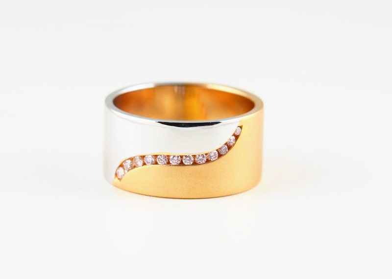 A wide band, half rose gold and half white gold, with a diagonal line of small diamonds