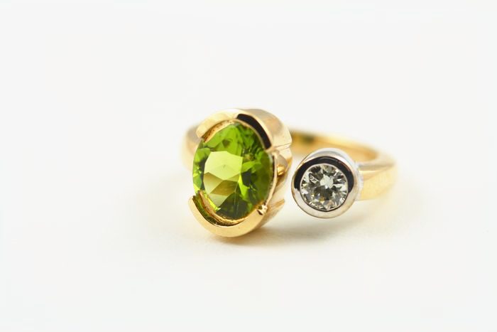 Peridot two-stone ring: a Peridot with a diamond in 18 karat yellow and white gold
