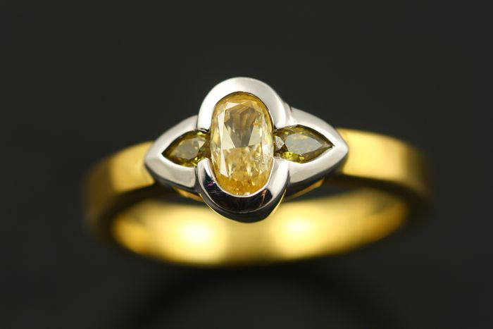 Oval ring: three yellow diamonds set in 18 karat white gold with an 18 karat yellow gold band