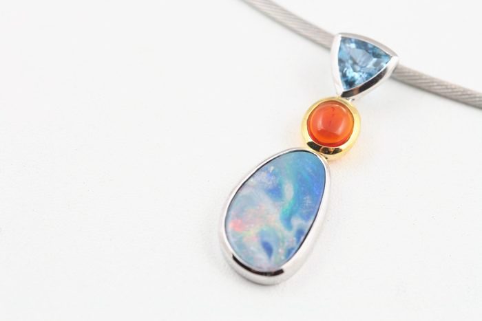 Boulder Opal pendant: a Boulder Opal with blue Topaz and Fire Opal in 18 karat gold