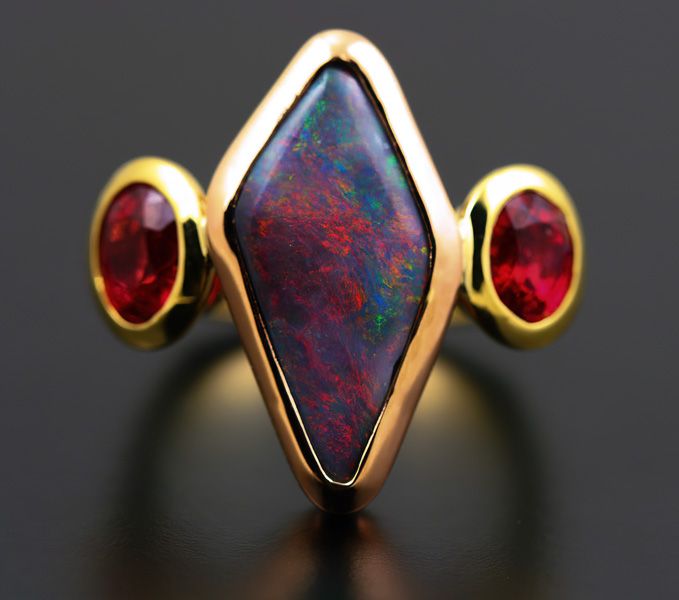 Black Opal and Spinel ring: a Black Opal with red Spinels in 18 karat yellow and rose gold