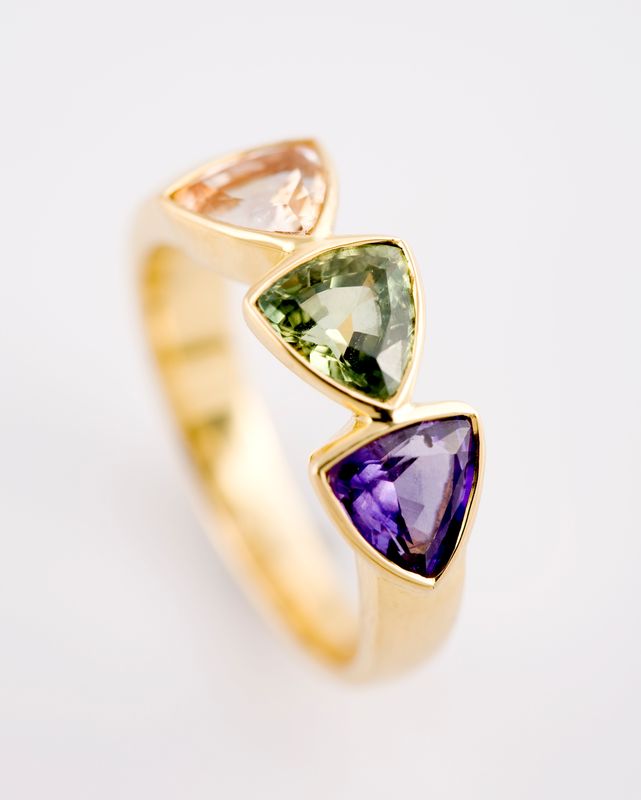 Yellow gold ring with three angular stones in peach, green and violet